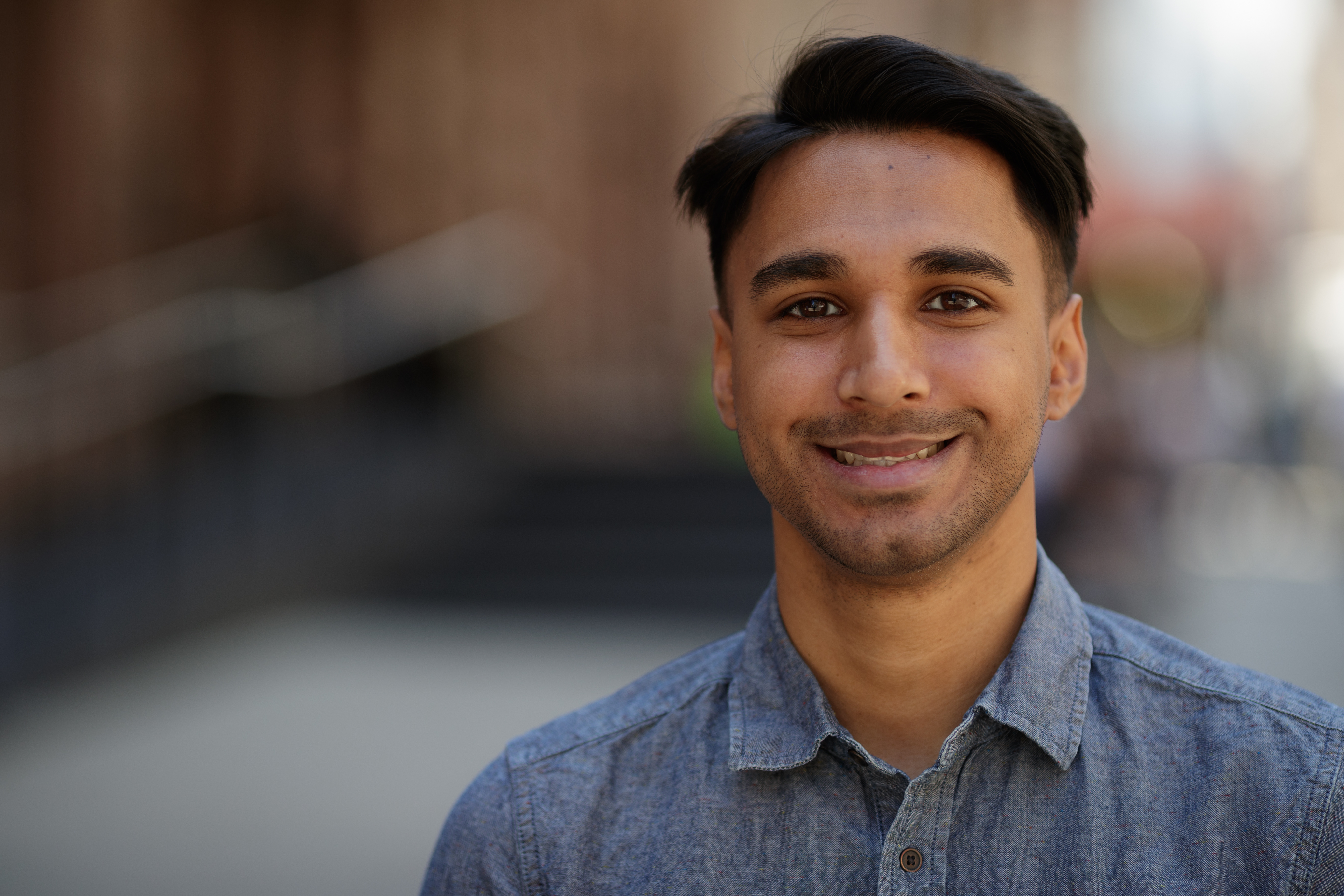 Young Indian  man in city face  portrait smile BARE 